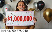 Smiling woman holds a large check for one million dollars surrounded by confetti and balloons for financial success footage. Стоковое AI-видео, аниматор Анжелика Самсонова / Фотобанк Лори