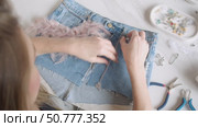A fashion designer creates a custom skirt with various embellishments, such as a chain of feathers and beads. Стоковое видео, видеограф Strunov David / Фотобанк Лори