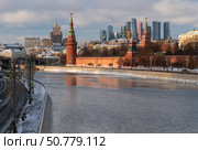 Vodovzvodnaya, Blagoveshchenskaya and Borovitskaya towers on the Kremlin embankment of the Moskva River and the Moscow City Business Center in the background on a sunny winter day, Moscow, Russia. Стоковое фото, фотограф Ula Ulachka / Фотобанк Лори