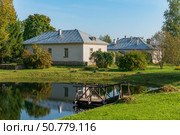 View of residential buildings in the Petrovskoye estate of the Pushkin Museum-Reserve with reflection in the Park Pond on a sunny summer day, Pushkinskiye Gory, Pskov Region, Russia. Стоковое фото, фотограф Ula Ulachka / Фотобанк Лори