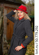 A beautiful blonde elderly woman in an extravagant red hat and a gray coat. Стоковое фото, фотограф Лазаренко Светлана / Фотобанк Лори