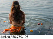 Indian woman performing hindu ritual in the ganges river. Стоковое AI-изображение, AI-художник Иван Рябоконь / Фотобанк Лори