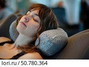 Young woman sleeping comfortably on travel pillow during trip. Стоковое AI-изображение, AI-художник Иван Рябоконь / Фотобанк Лори
