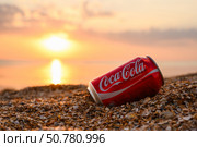 Anapa, Russia - July 2025: Coca-Cola on the evening seashore. Coca-Cola can close-up. Редакционное фото, фотограф Никита Бурденков / Фотобанк Лори