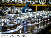 Manufacturing line of shiny new alloy wheels being produced. Стоковое AI-изображение, AI-художник Иван Рябоконь / Фотобанк Лори