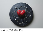 Red heart shape surrounded by silver orbits representing love atom. Стоковое AI-изображение, AI-художник Иван Рябоконь / Фотобанк Лори