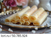 Rolled pancakes forming a pyramidal shape on a golden tray. Стоковое AI-изображение, AI-художник Иван Рябоконь / Фотобанк Лори