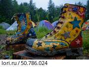 Colorful star studded boots at outdoor campground. Стоковое AI-изображение, AI-художник Иван Рябоконь / Фотобанк Лори