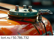 Close up of restored vintage vehicle showing radiator cap and spark plug. Стоковое AI-изображение, AI-художник Иван Рябоконь / Фотобанк Лори