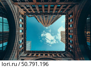 Modern buildings framing a cloudy blue sky. Стоковое AI-изображение, AI-художник Иван Рябоконь / Фотобанк Лори