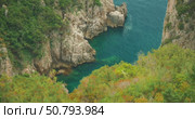 A rocky cove with clear blue water seen from above during a summer trip in Capri. Стоковое видео, видеограф Igor Tichonow / Фотобанк Лори