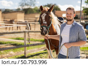 Young man leading horse by bridle. Стоковое фото, фотограф Яков Филимонов / Фотобанк Лори