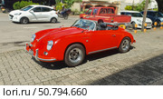 Красный спортивный ретроавтомобиль на фоне современной городской среды. Porsche 356 Speedster (2023 год). Редакционное фото, фотограф Кристина Куксова / Фотобанк Лори