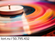 Spinning colorful vinyl record on turntable. Стоковое AI-изображение, AI-художник Иван Рябоконь / Фотобанк Лори