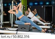 Young woman sitting on box set equipment reformer performs for abdominal muscles. Стоковое фото, фотограф Яков Филимонов / Фотобанк Лори