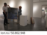Мужчина и женщина распаковывают картины. Редакционное фото, фотограф Дмитрий Неумоин / Фотобанк Лори