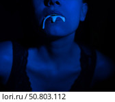 A thick white liquid flows down the lips of a young European girl. Dripping down. Ultraviolet, blue light. Close-up portrait. Spit out. Стоковое фото, фотограф Михаил Решетников / Фотобанк Лори
