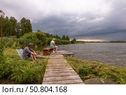 Мужчины ловят рыбу на берегу озера. Редакционное фото, фотограф Андрей Иванов / Фотобанк Лори