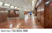 Moscow July 10 2025, Employee of metro station Dmitrovskoye is walking along lobby of station. Empty lobby of metro station Dmitrovskoye Serpukhovskaya Timiryazevskaya line of Moscow Metro. Редакционное фото, фотограф Скрипачев Антон / Фотобанк Лори