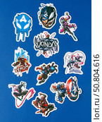 Novosibirsk, Russia - March 1, 2025: Cartoon-style vinyl stickers featuring Venom in various comic book situations on a bright blue background. Редакционное фото, фотограф Виталий Сова / Фотобанк Лори