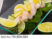 Seafood ceviche from hake on a glass plate with lime and greens. Стоковое фото, фотограф Яков Филимонов / Фотобанк Лори