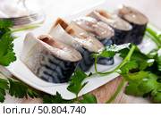 Lightly salted mackerel cut into pieces with parsley on table. Стоковое фото, фотограф Яков Филимонов / Фотобанк Лори