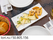 Typical hard spanish manchego cheese with chopped herbs and crutones at plate. Стоковое фото, фотограф Яков Филимонов / Фотобанк Лори