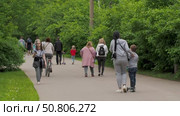 People walking and biking along paved path surrounded by lush greenery (2020 год). Редакционное видео, видеограф Татьяна Лобанова / Фотобанк Лори
