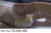 Slow-motion video of bicycle leg massage for an infant under one year to improve hip and knee joint mobility. Pediatric physiotherapy technique. Стоковое видео, видеограф Татьяна Степанищева / Фотобанк Лори
