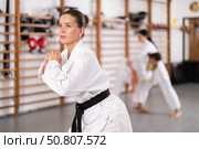 Young girl wearing kimono doing exercises in sports hall. Стоковое фото, фотограф Яков Филимонов / Фотобанк Лори
