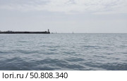 Sailboats Navigate Calm Waters Near Lighthouse and Harbor in Yalta. Стоковое видео, видеограф Roman Zavorotny / Фотобанк Лори