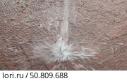 A dynamic water splash captured on a brick pavement, showing droplets in mid-air as they hit the ground. The image highlights the impact and texture of both water and surface. Стоковое видео, видеограф Marina Gabdullina / Фотобанк Лори