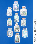 Novosibirsk, Russia - May 30, 2025: Vinyl stickers in a playful cartoon style featuring a whimsical world inside a glass jar. These designs showcase adorable cats and puppies surrounded by lush greenery, colorful flowers, and tiny creatures, creating a charming and lively scene. Редакционное фото, фотограф Виталий Сова / Фотобанк Лори