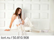 A Young Model Poses Gracefully in a Studio, Dressed in Chic, Minimalistic Attire. Стоковое фото, фотограф Aleksandr Golubev / Фотобанк Лори