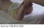 Slow-motion video of infant leg massage with back stroking to enhance hip and knee joint mobility. Pediatric physiotherapy session. Стоковое видео, видеограф Татьяна Степанищева / Фотобанк Лори