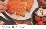 Female hands rubbing crispy golden toast with fresh tomato while preparing traditional Spanish Pan Con Tomate with Mediterranean flavor of olive oil and garlic. Стоковое видео, видеограф Яков Филимонов / Фотобанк Лори