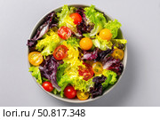 Vibrant salad from fresh lettuce and juicy cherry tomatoes in a ceramic bowl on a beige background. Tomato leafy greens salad with herbs and spices. Healthy food diet cuisine. Fresh nutrition plate. Стоковое AI-изображение, AI-художник Марина Демидюк / Фотобанк Лори