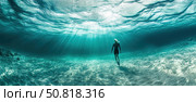 A breathtaking underwater photograph of a woman walking on the ocean floor with sunlight shining through the surface of the water. The rays of light create a magical atmosphere of calm and freedom. The clarity of the water, the sandy bottom and the sense of serenity highlight the harmony between man and nature. Ideal for themes: freediving, oneness with nature, meditation, inner silence, underwater world. Стоковое AI-изображение, AI-художник Анна Кривицкая / Фотобанк Лори