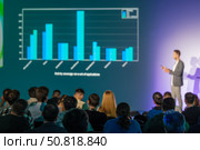 Speaker presenting data to attendees with bar chart on large screen. Стоковое фото, фотограф Антон Гвоздиков / Фотобанк Лори