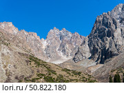 Ala-Archa Park, Steep rocky mountains rise sharply with jagged summits and sparse greenery. Trekking routes alpine climbing hiking expeditions and wilderness adventure in remote backcountry terrain. Стоковое фото, фотограф Андрей Ка / Фотобанк Лори