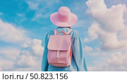 Back View of Traveler in Denim Jacket with Pink Hat & Backpack Against a Cloudy Sky. Стоковое AI-видео, аниматор Данила Большаков / Фотобанк Лори