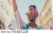 Empowered Spirit: Woman with Raised Arm, Head Wrap, and Sunglasses in Protest. Стоковое AI-видео, аниматор Данила Большаков / Фотобанк Лори