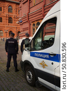 Police officers are on duty near a patrol car.  Russia. Moscow. 21.07.25. Редакционное фото, фотограф Ярославский Максим / Фотобанк Лори