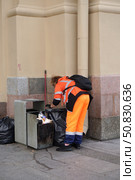 A man in an orange jumpsuit is cleaning up trash from a trash can. Стоковое фото, фотограф Ярославский Максим / Фотобанк Лори