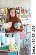 Selective young female customer choosing convenient body washcloth in large retail store. Стоковое видео, видеограф Яков Филимонов / Фотобанк Лори