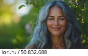 Content Woman with Wavy Silver Hair and a Gentle Smile, Bathed in Natural Light Outdoors. Стоковое AI-видео, аниматор Данила Большаков / Фотобанк Лори