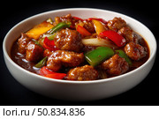Sweet sour pork with colorful peppers, mixed vegetables served in a black bowl on dark concrete background. Traditional Chinese dish. Close-up. The meat pieces in a brown sauce glaze. Sichuan cuisine. Стоковое AI-изображение, AI-художник Марина Демидюк / Фотобанк Лори