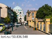 Yevpatoria, Russian Federation - July 05, 2025: Street view of a vibrant city with a stunning blue-domed church in the background, showcasing urban architecture and lively atmosphere. Редакционное фото, фотограф Ирина Ручушкина / Фотобанк Лори