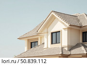 House Exterior. Roof Window. Second floor among blue sky. Mansard attic. Newly build houses. Gable roof with skylight, asphalt roofing, shingles. Residential Home. Vinyl Siding. Polymeric roof-tiles. Стоковое AI-изображение, AI-художник Марина Демидюк / Фотобанк Лори