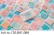 Vintage Correspondence: Nostalgic Arrangement of Colorful Stamps with Centered Small Mailing Envelope. Стоковое AI-изображение, AI-художник Данила Большаков / Фотобанк Лори